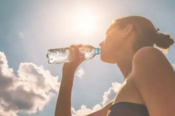 Hydration: The Secret Ingredient for a Toned Stomach and Enhanced Fitness 3 Image of woman drinking water to hydrate Oxford after run.