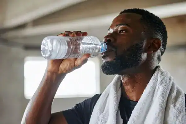 Hydration: The Secret Ingredient for a Toned Stomach and Enhanced Fitness 1 Image of man drinking water to improve hydration Oxford after work out.